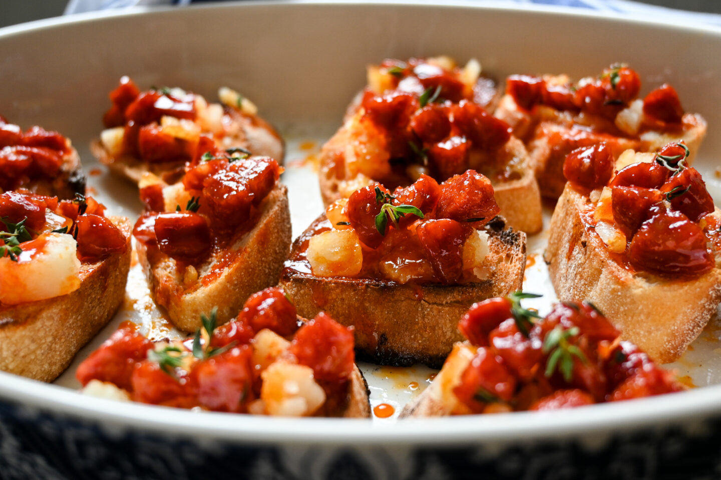 Honey Glazed Chorizo with Manchego Cheese on small slices of toasted baguette in a close-up shot