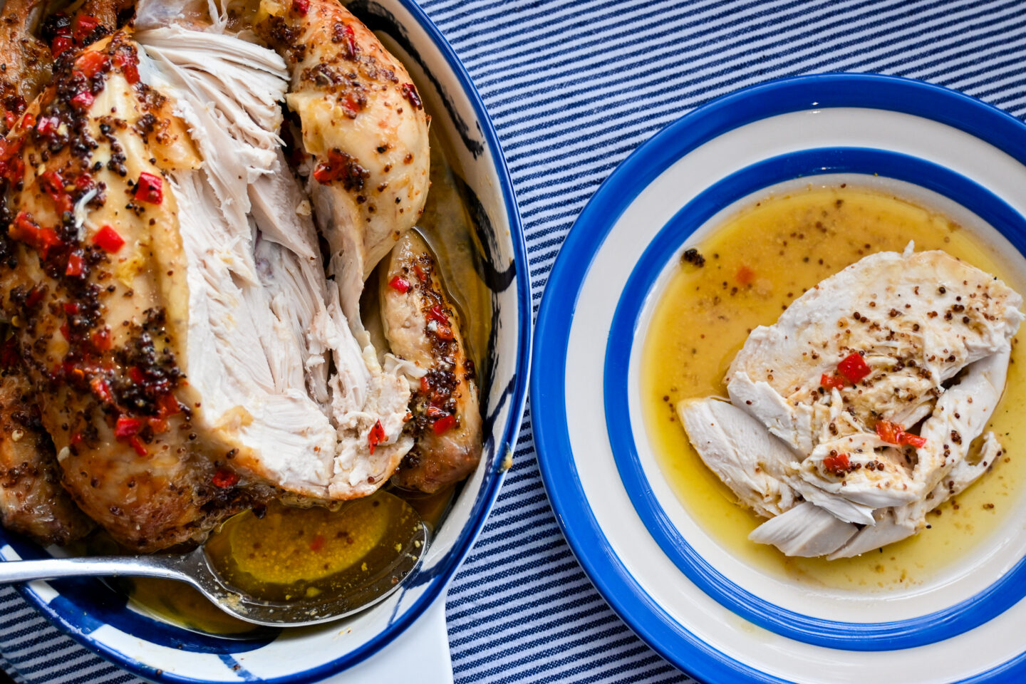 Partially carved Roast Chicken with a serving on a blue & white cornishware plate on a blue & white striped background