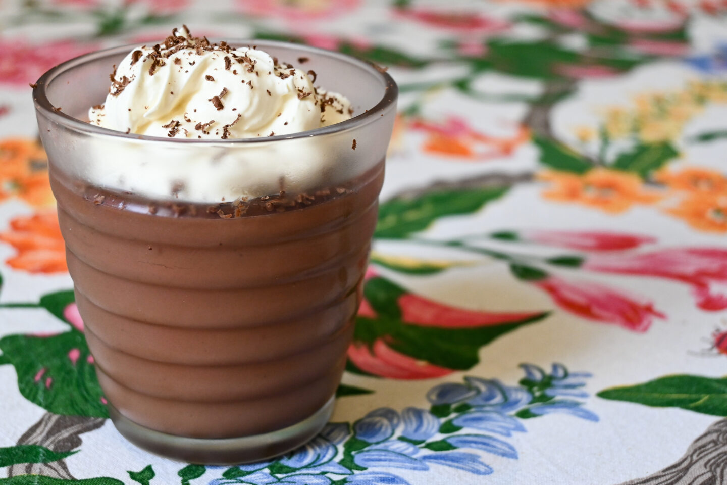 Chocolate Pudding in a small glass topped with whipped cream and chocolate shavings