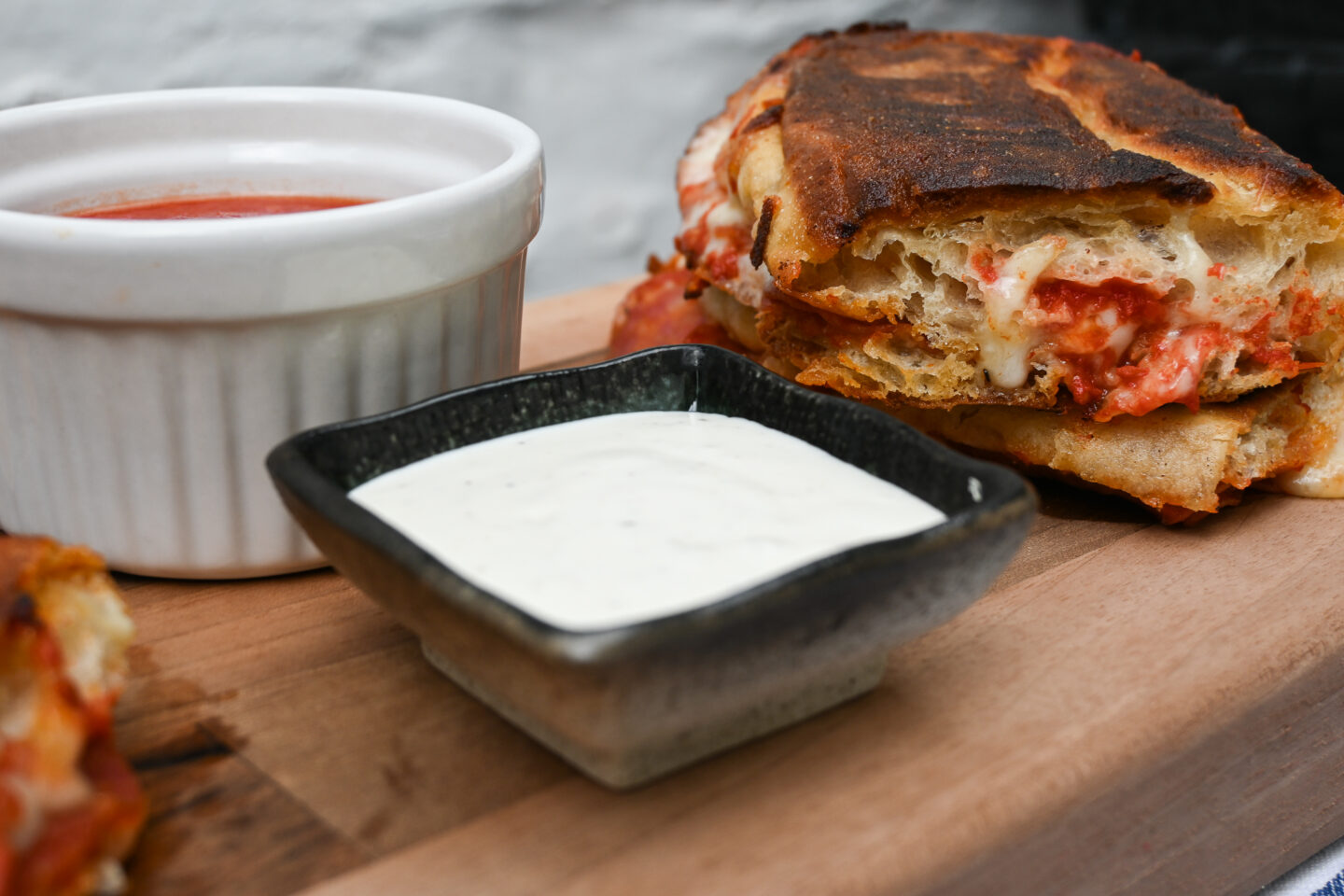 Close up of pepperoni pizza panini with ranch & pizza sauces for dipping