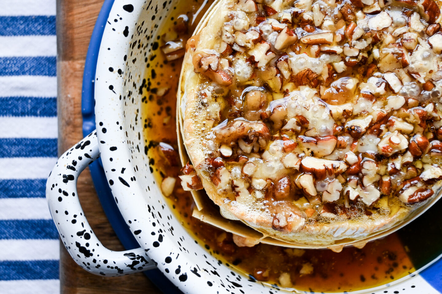 Closeup of baked camembert with maple syrup & chopped pecans