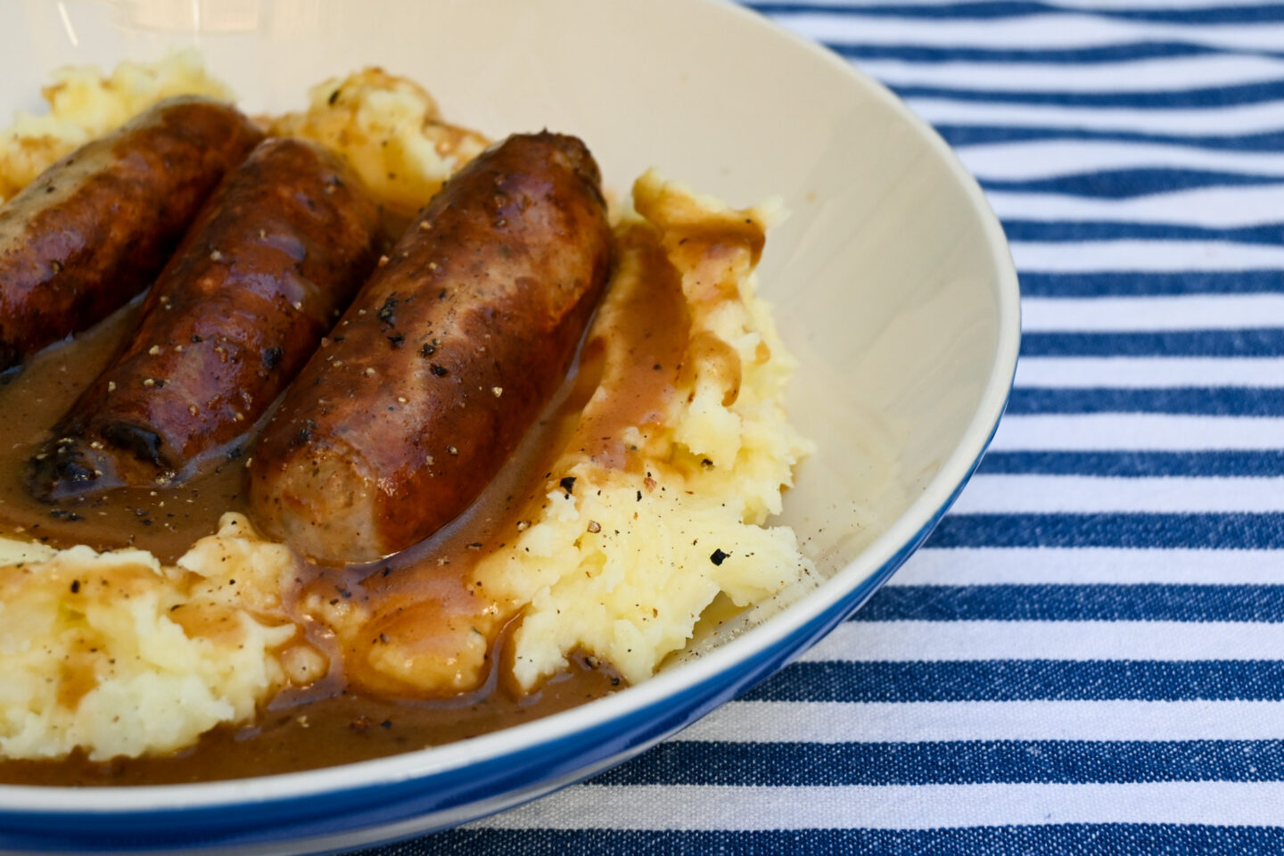 Closeup of sausages & mash with gravy