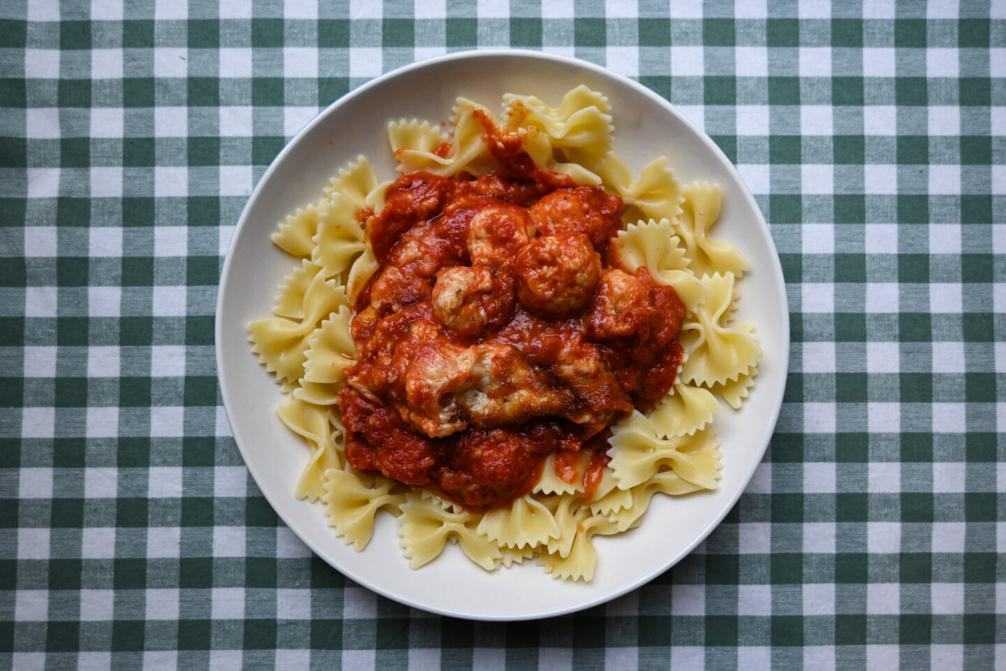 Cheesy Chicken Meatballs served atop a bed of bowtie pasta