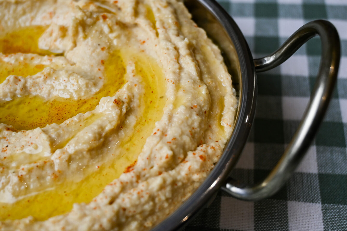 Closeup of Roasted Garlic & Lemon Hummus drizzled with olive oil & sprinkled with a scant amount of Cayenne Pepper