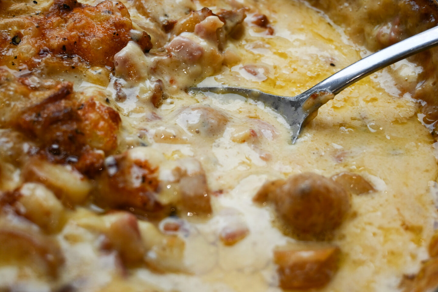 Tartiflette with serving spoon closeup to see the melted texture