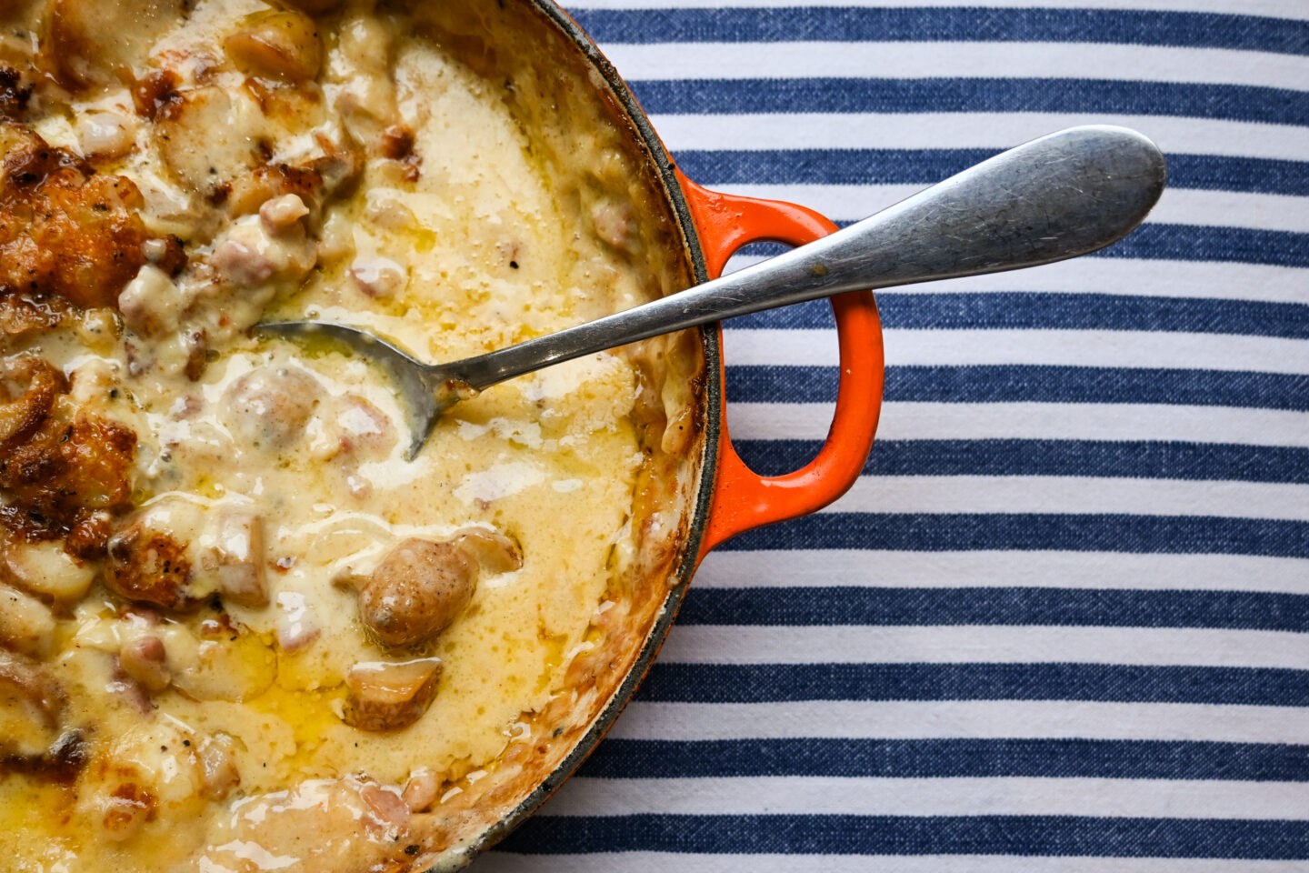 Side shot of Tartiflette with serving spoon