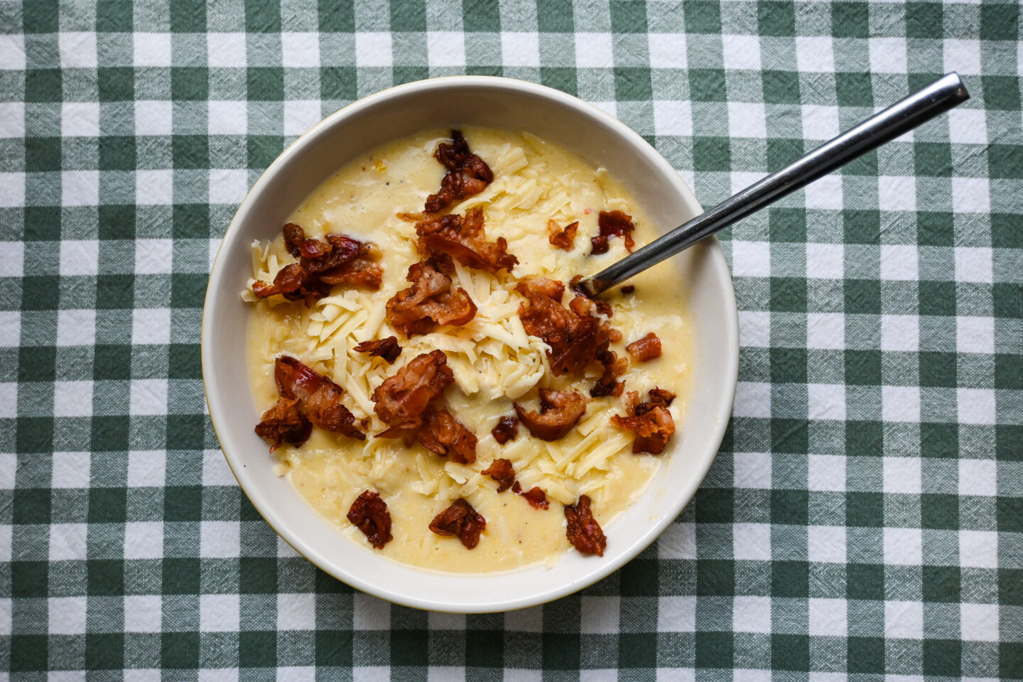 Chicken & Corn Chowder sprinkled across the top with black pepper, shredded cheddar cheese and crumbled crispy fried pancetta