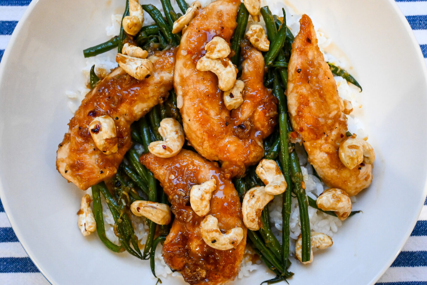 Chicken Mini Fillets glazed in a honey & garlic sauce on a bed of sticky white rice with green beans and cashews