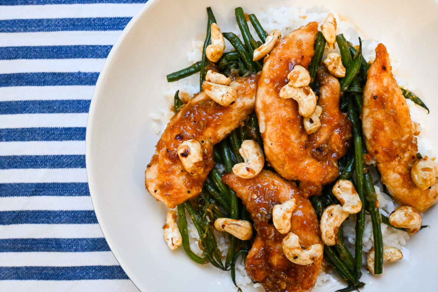 Chicken Mini Fillets glazed in a honey & garlic sauce on a bed of sticky white rice with green beans and cashews