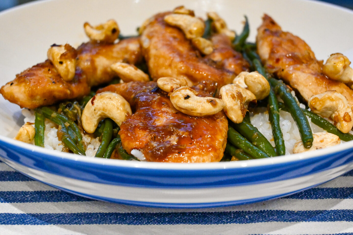 Chicken Mini Fillets glazed in a honey & garlic sauce on a bed of sticky white rice with green beans and cashews