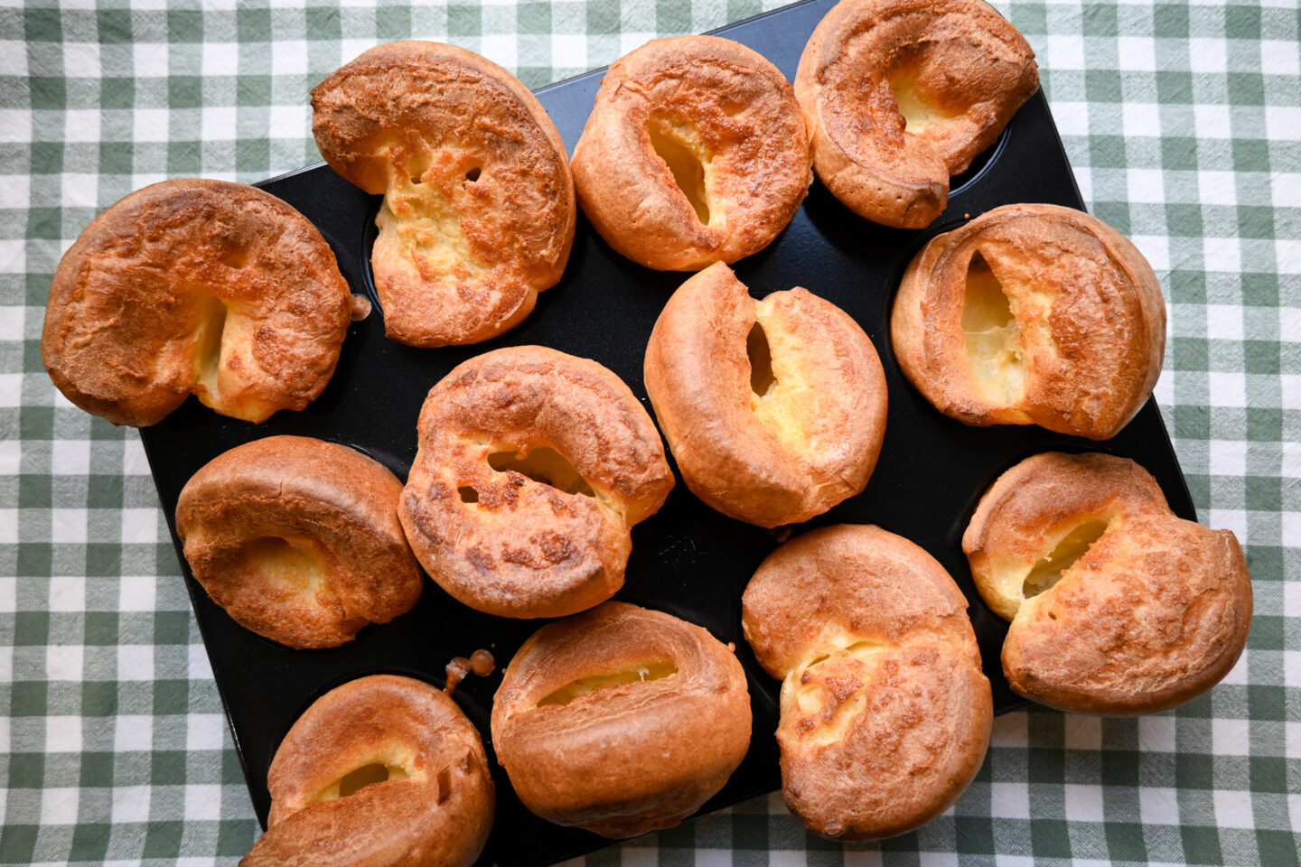 Miniature Yorkshire Puddings in a Muffin Tin on a green & white gingham background