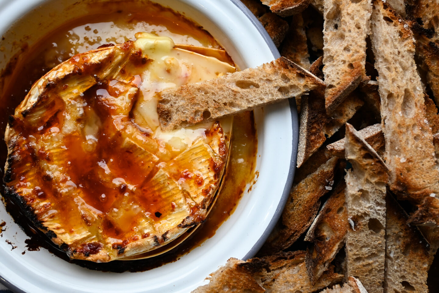 Closeup of Harissa Honey Baked Camembert with toasted sourdough bread