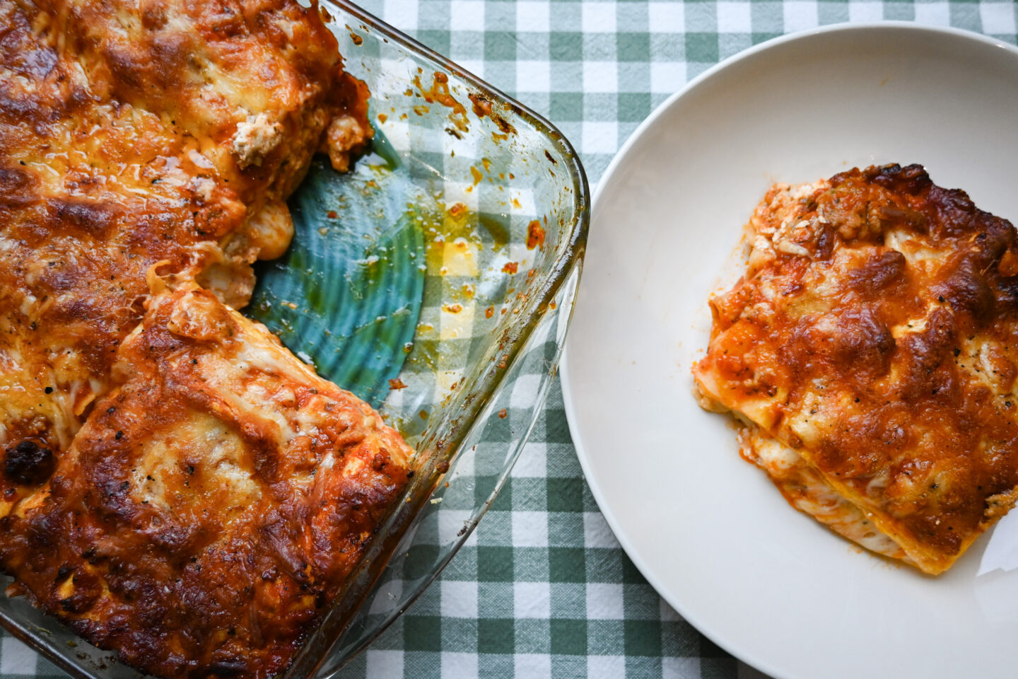 Glass baking dish of Sausage & Mint Lasagna alongside a slice on a plate